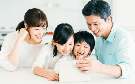 家族4人でPCをみている写真